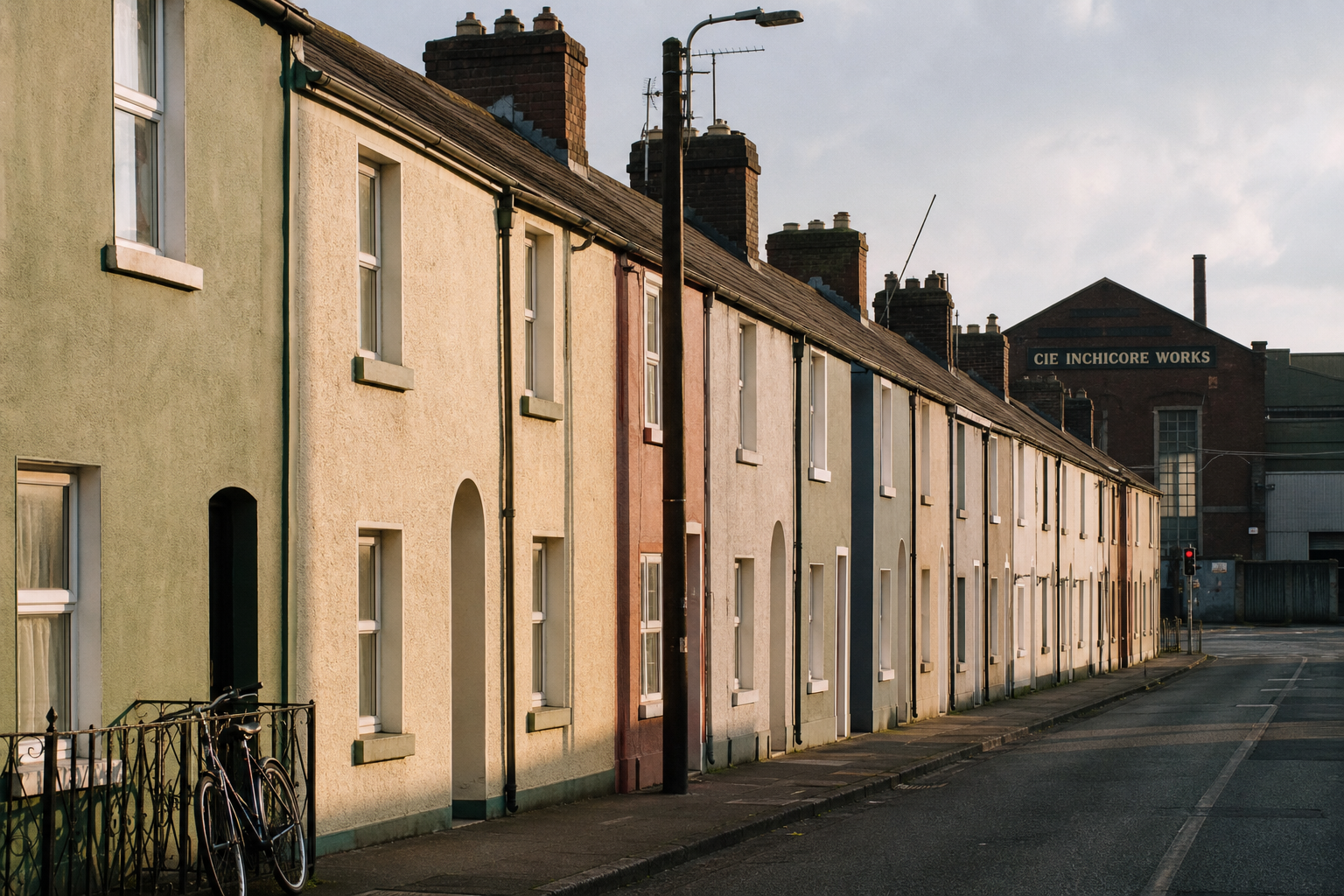 A row of painted Victorian railway-worker cottages on Tyrconnell Road, Inchicore, under late-afternoon Dublin light